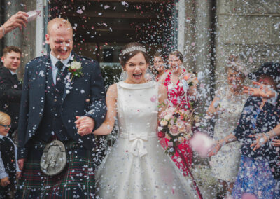Bride and groom with confetti thrown after the ceremony