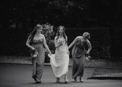 Black and white photo of bride and bridesmaids walking to ceremony