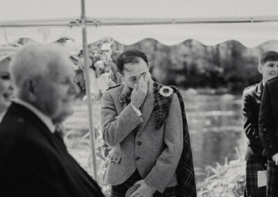 Black and whte image of groom in tears at ceremony