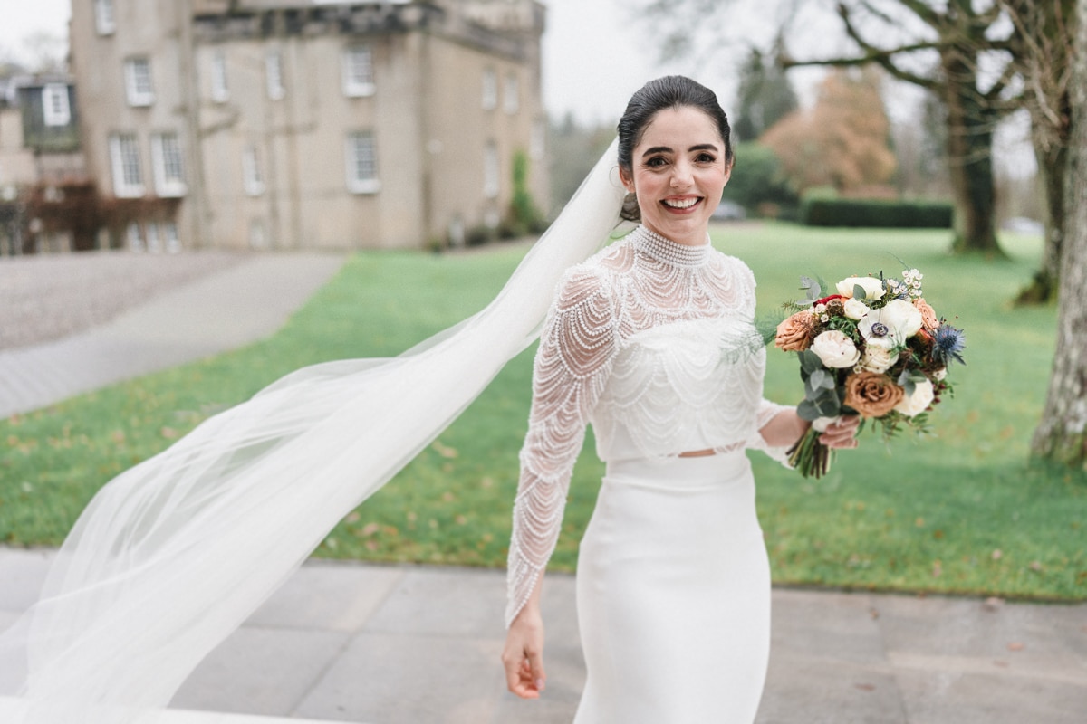 A bride smiles outside Boturich, overlooking Loch Lomond