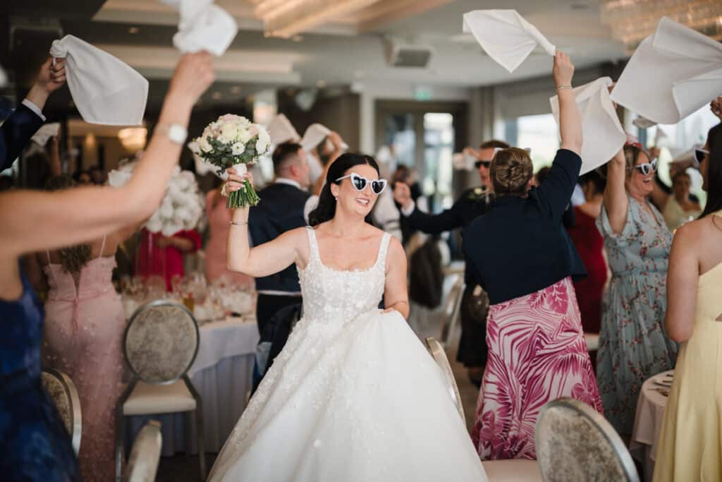 Bride wearing sunglasses walks in during her Lochside House Hotel Wedding