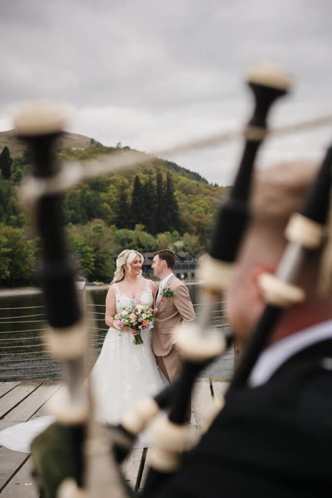 Bride and groom by Loch Lomond with piper