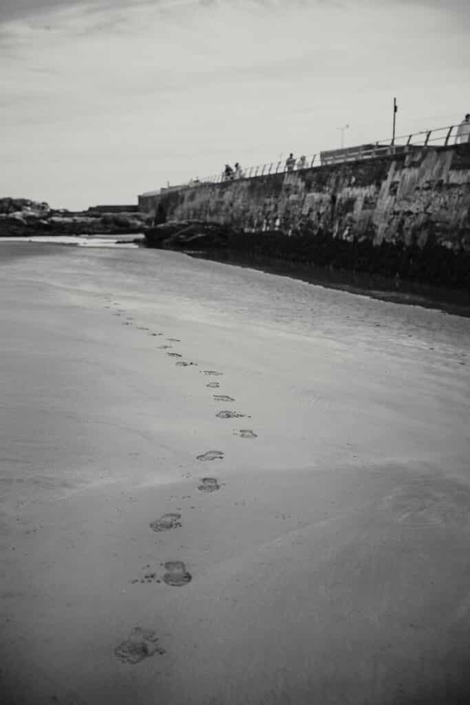 Black & White photo of footsteps in the sand of West Sands beach